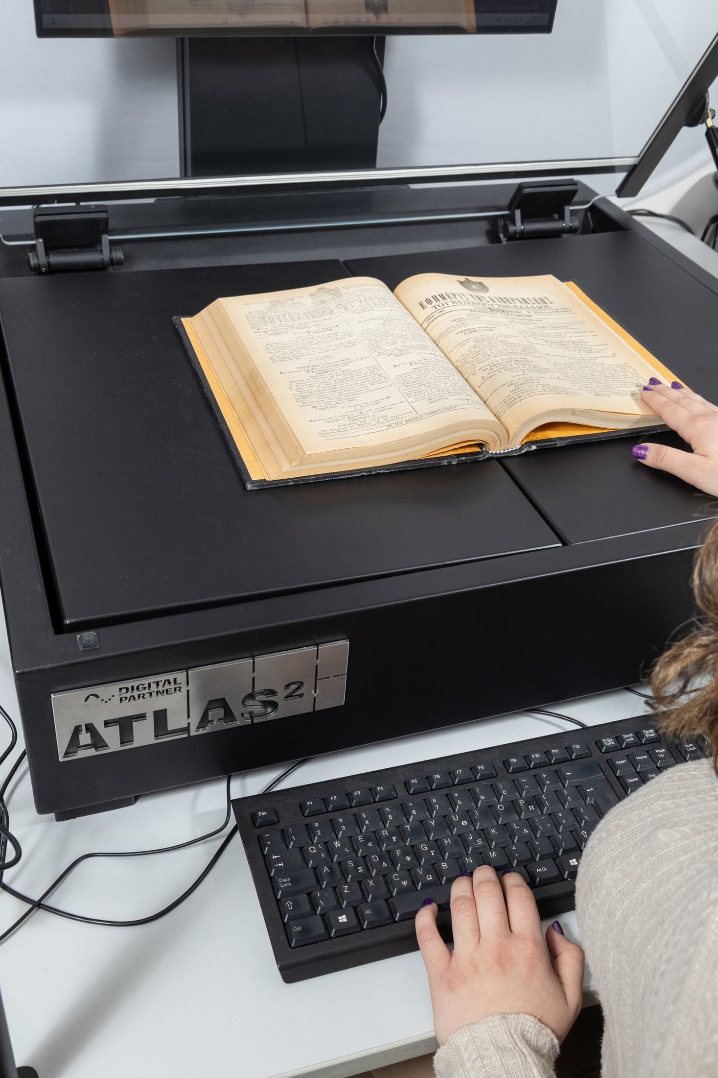 Photo of the Atlas 2 scanner, while scanning an old book